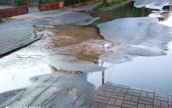 Kałuże wody znajdujące się na jezdni ul. Konarskiego w Braniewie. 