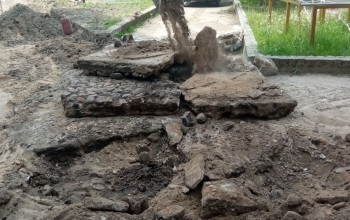 Łyżka koparki wykonuje rozbiórkę nawierzchni bitumicznej na terenie dziedzińca Szkoły Podstawowej nr 6 w Braniewie.