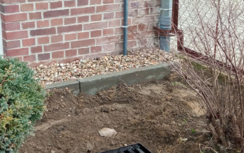 Krata kanalizacji deszczowej znajdująca się w trawniku na rogu budynku Szkoły Podstawowej nr  6 Braniewie.